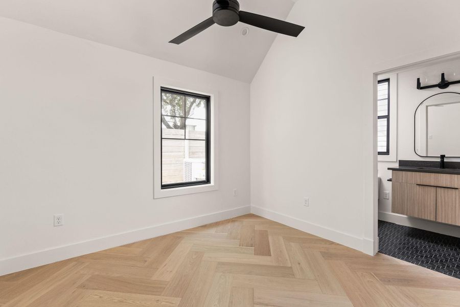 Unfurnished bedroom featuring vaulted ceiling and a ceiling fan Unfurnished bedroom featuring vaulted ceiling and a ceiling fan