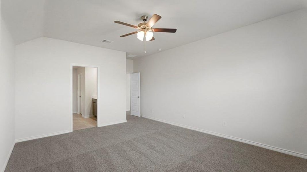Spacious room featuring vaulted ceilings, neutral-toned walls, and plush carpeting