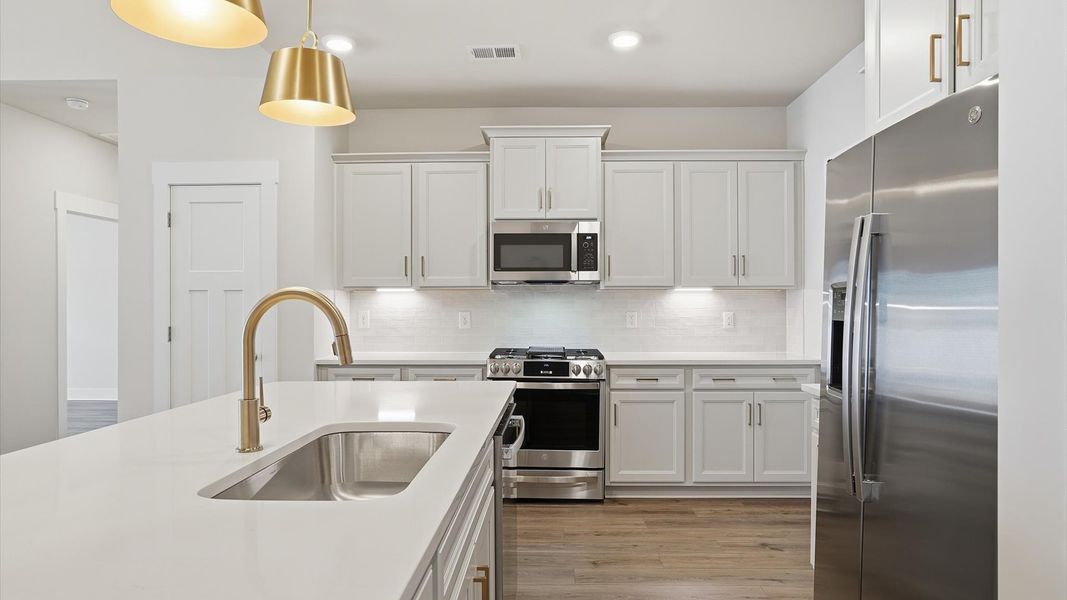 Memorable meals begin in this vibrant kitchen with pendant lighting and a thoughtfully designed island by DRB Homes Memorable meals begin in this vibrant kitchen with pendant lighting and a thoughtfully designed island by DRB Homes