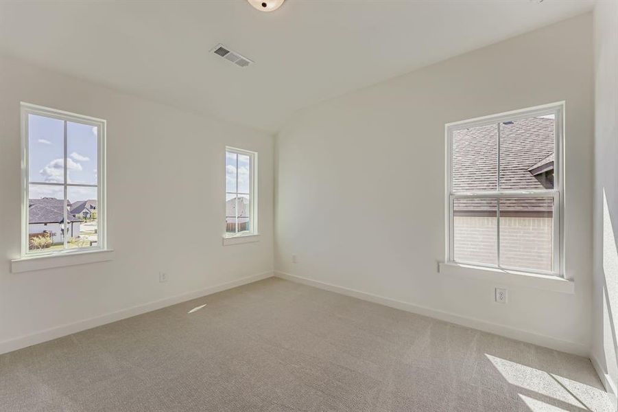 Spare room with lofted ceiling and light carpet