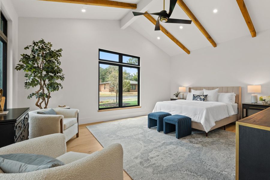 Vaulted ceilings with exposed timber beams highlight this grand bedroom space.