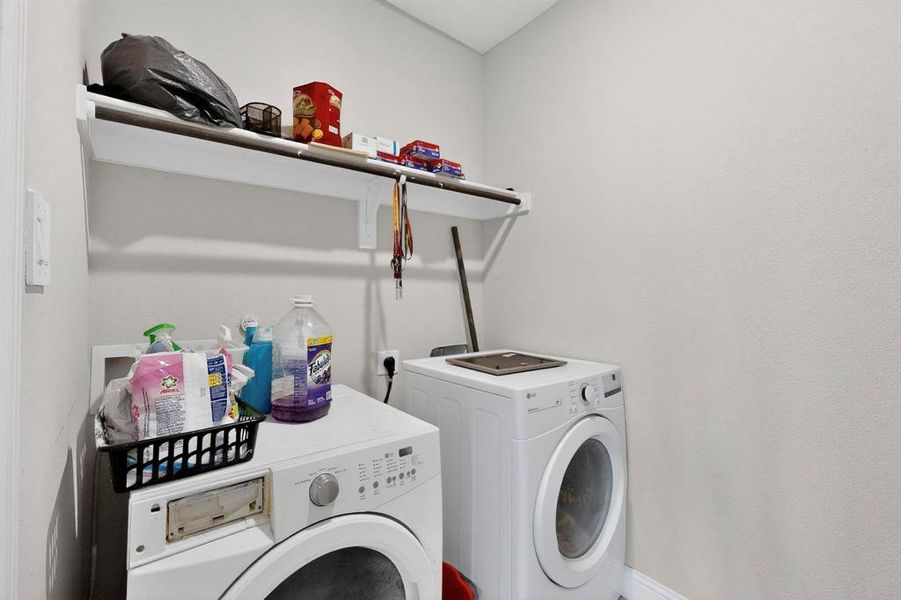 Laundry room with washing machine and dryer and baseboards Laundry room with washing machine and dryer and baseboards