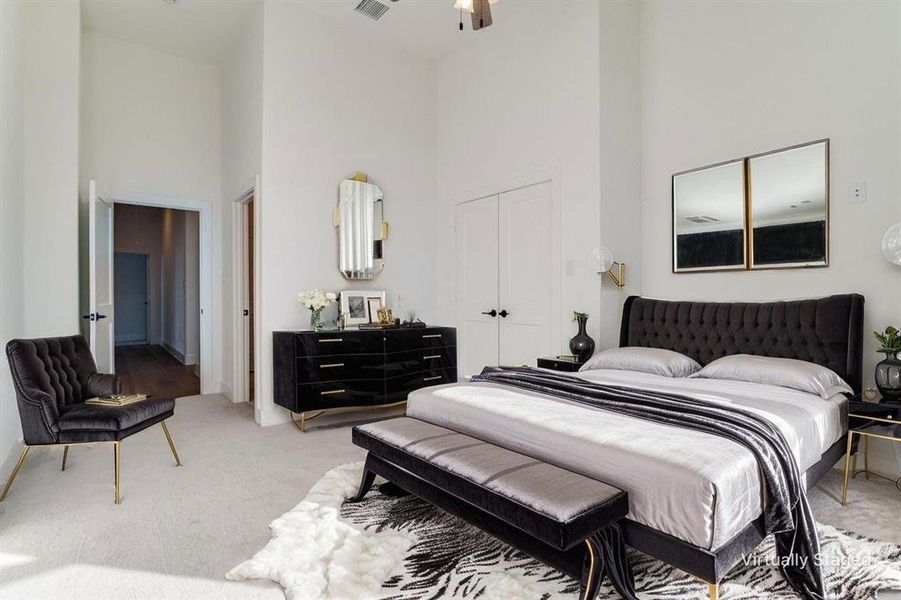 Bedroom featuring a towering ceiling, light carpet, and a closet