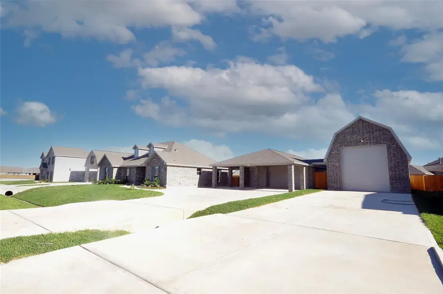 Front exterior of a new home in Pedregal, League City, TX, highlighting curb appeal (Image 21).