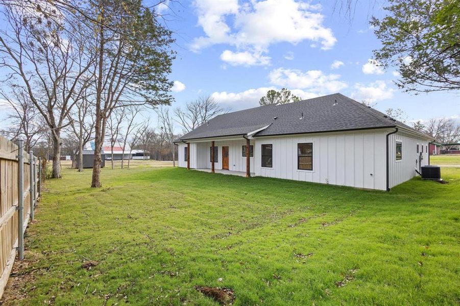 Rear view of property featuring roof with shingles and a patio area