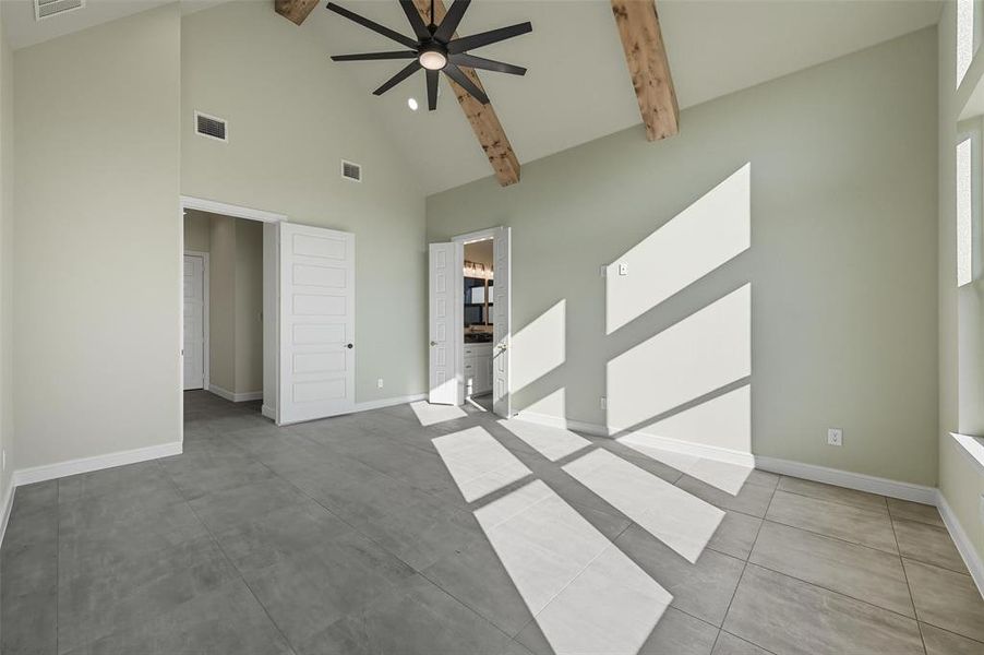 Unfurnished bedroom with high vaulted ceiling, beamed ceiling, a ceiling fan, and ensuite bathroom Unfurnished bedroom with high vaulted ceiling, beamed ceiling, a ceiling fan, and ensuite bathroom