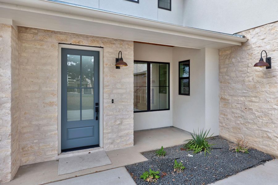 Front entry and patio showing the custom german schmear limestone masonry and stucco on the home exterior