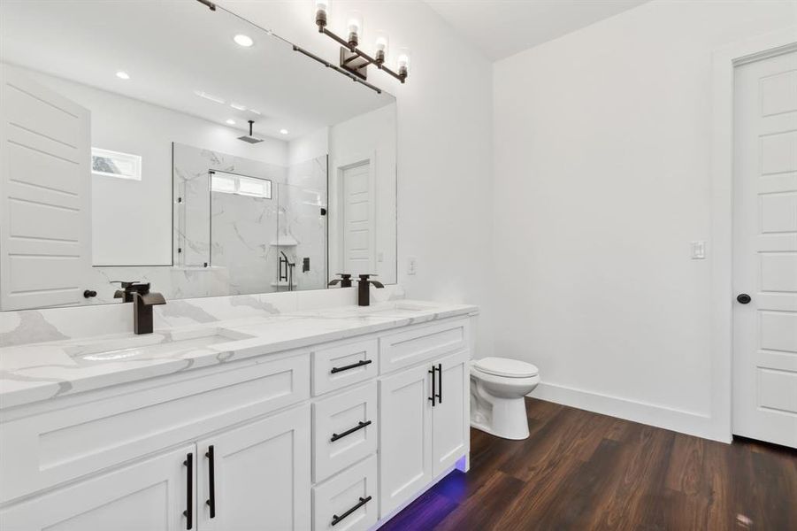 Bathroom with a shower with door, hardwood / wood-style flooring, vanity, and toilet