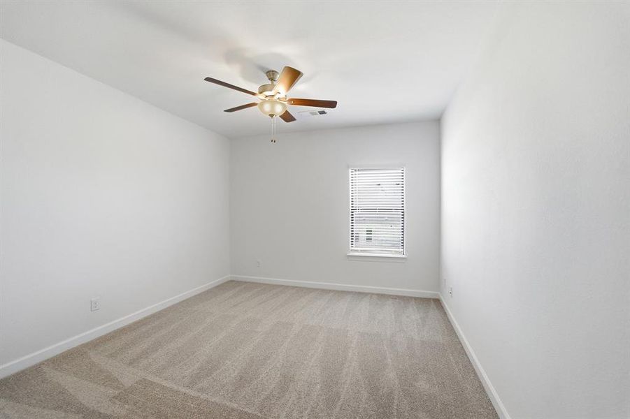 Spacious room featuring neutral carpet flooring and white walls Spacious room featuring neutral carpet flooring and white walls