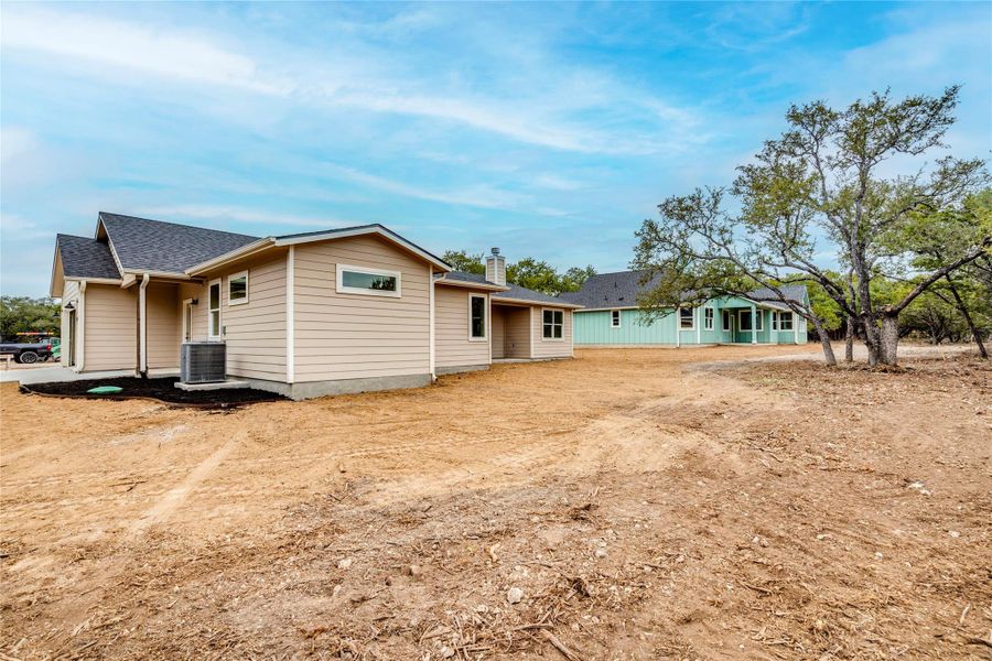 Rear view of house with roof with shingles and a chimney