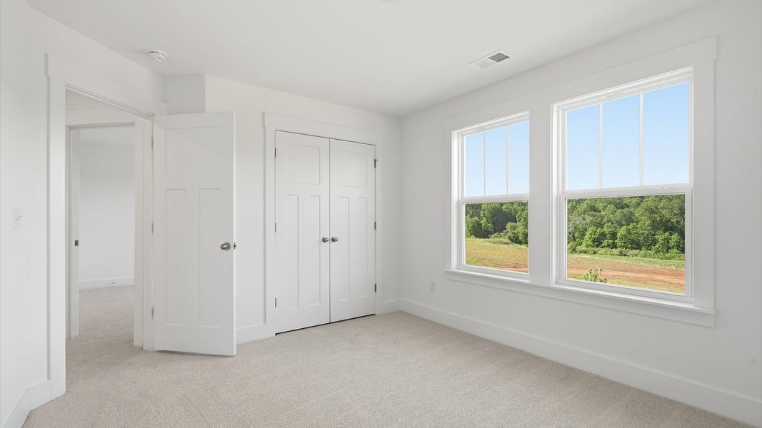Highly functional bedroom with walk-in closet and tasteful carpet for a restful retreat