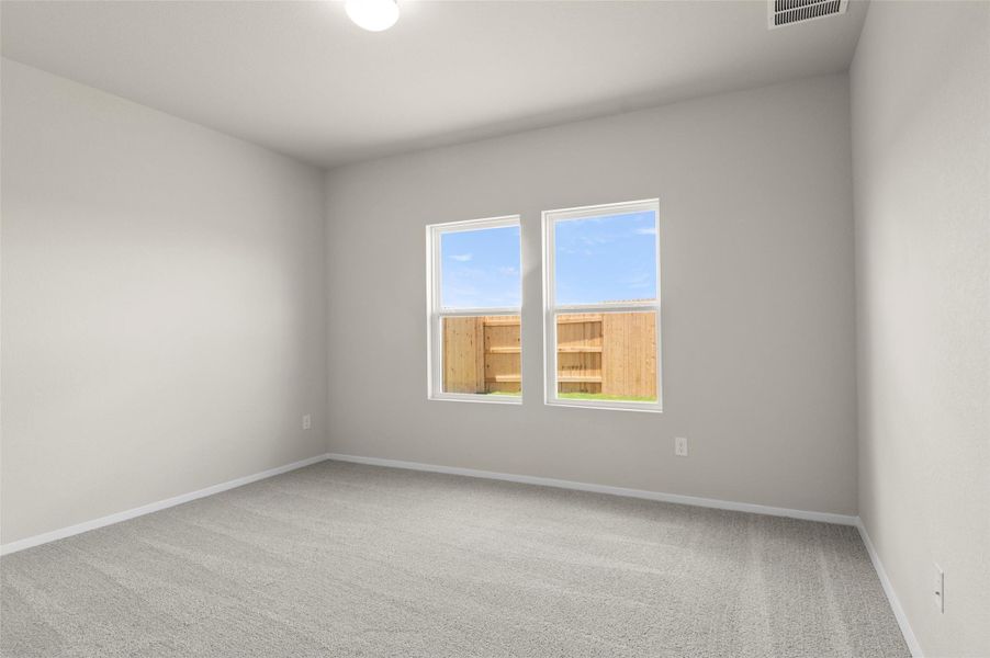 Empty room with carpet flooring and baseboards Empty room with carpet flooring and baseboards