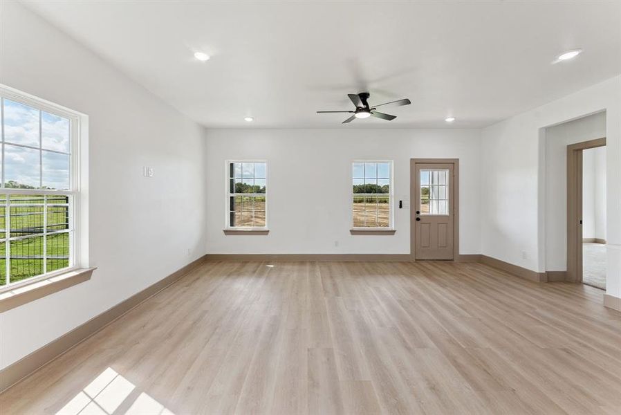 Unfurnished living room featuring healthy amount of natural light, light wood-type flooring, recessed lighting, and a ceiling fan Unfurnished living room featuring healthy amount of natural light, light wood-type flooring, recessed lighting, and a ceiling fan