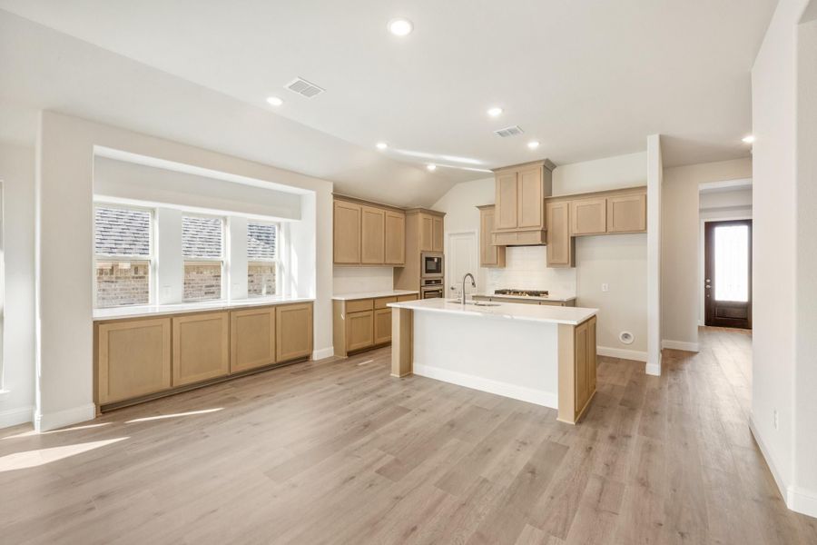 Open kitchen with light wood cabinets, center island with sink, and hardwood floors Open kitchen with light wood cabinets, center island with sink, and hardwood floors