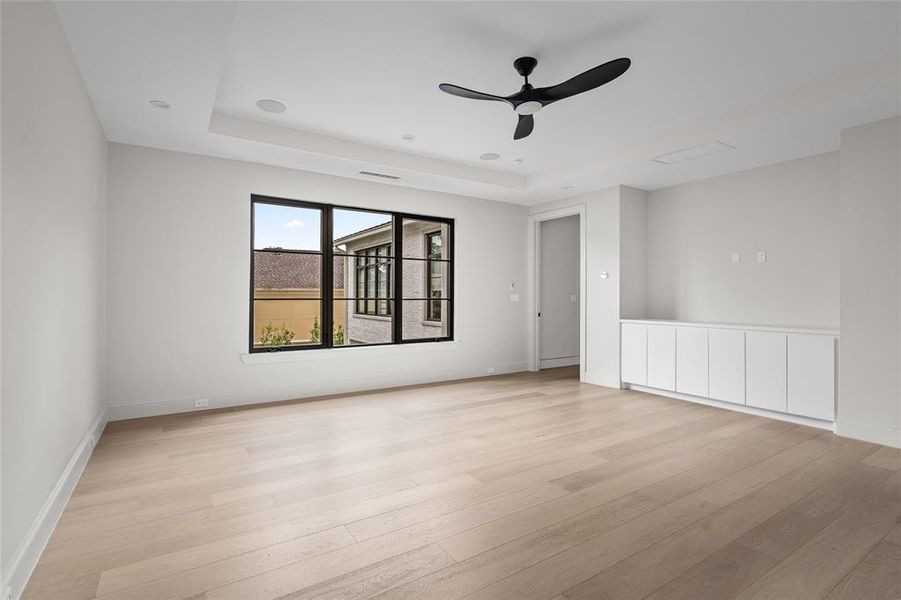 Bedroom 5, the largest of the secondary bedrooms, showcases bespoke built-in cabinetry, oversized windows that flood the space with natural light, and an elegant tray ceiling, creating a luxurious and inviting retreat.