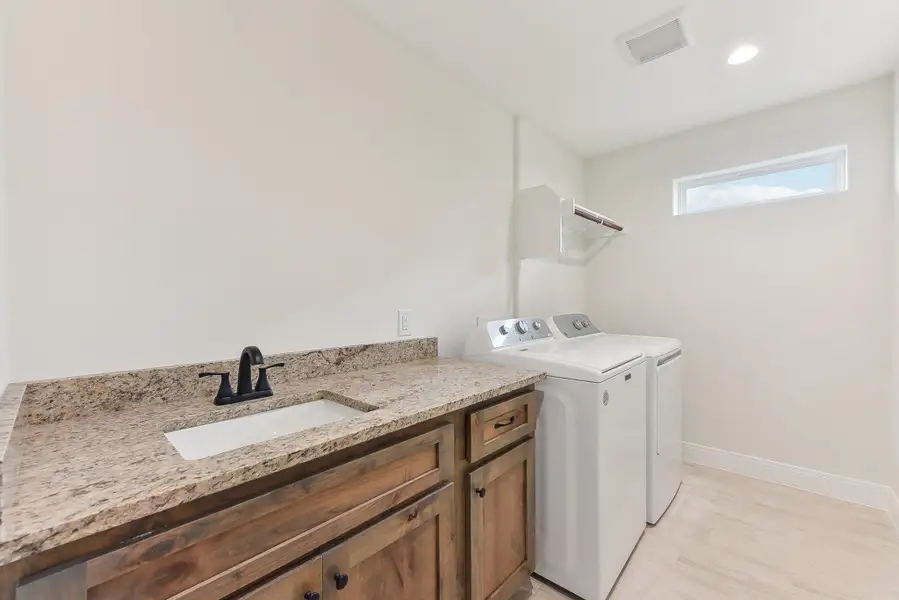 Upstairs Laundry Room featuring a sink, baseboards, visible vents, separate washer and dryer, and laundry area