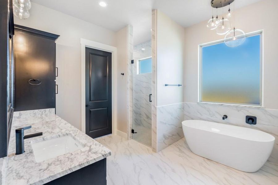 Bathroom with vanity, separate shower and tub, and a notable chandelier