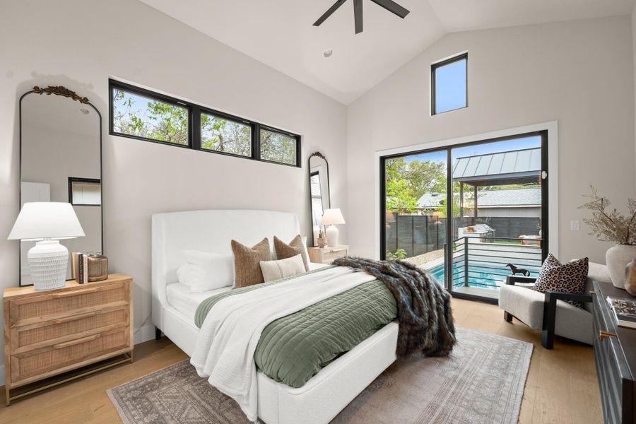 Bedroom with access to outside, light wood finished floors, ceiling fan, and high vaulted ceiling