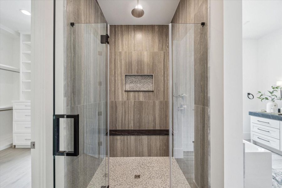 Framed glass shower with mosaic floor and niche design and Nero Marquina Marble bench create a cohesive space.