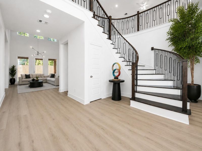 Grand formal entryway w/sweeping staircase w/real wood treads and contemporary spindles. Virtually staged floor plants and furniture and contemporary light fixture in ivingroom. Grand formal entryway w/sweeping staircase w/real wood treads and contemporary spindles. Virtually staged floor plants and furniture and contemporary light fixture in ivingroom.