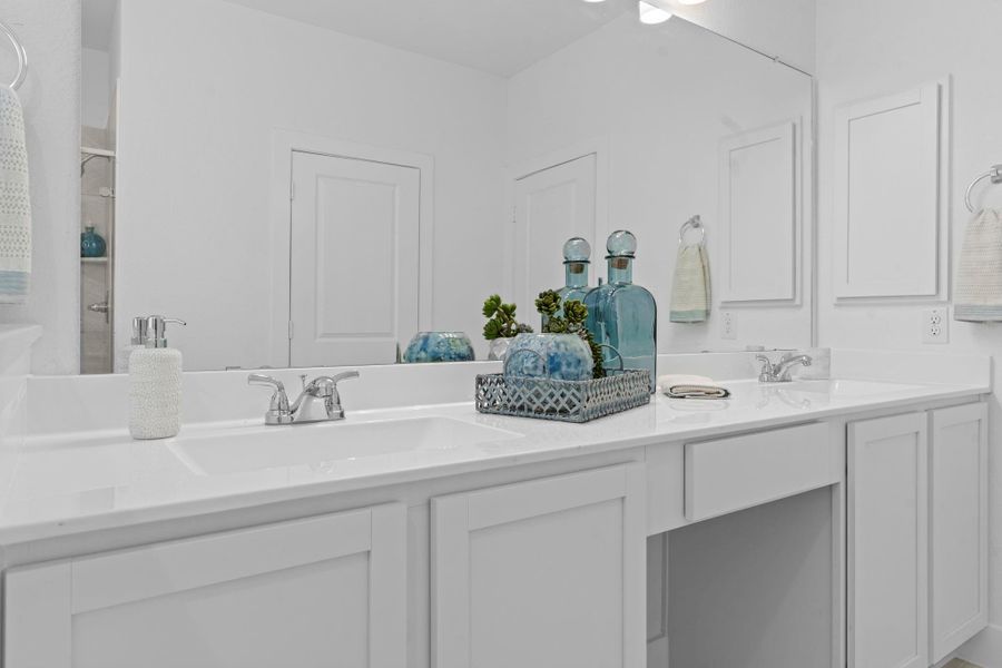 Extended dual vanity with cultured marble counters, framed mirrors, and stylish lighting provides plenty of space to prepare for the day in comfort and elegance. **Image Representative of Plan Only and May Vary as Built**.