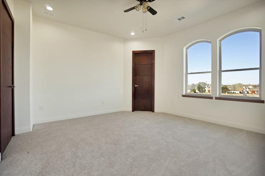 Spare room with light carpet and ceiling fan