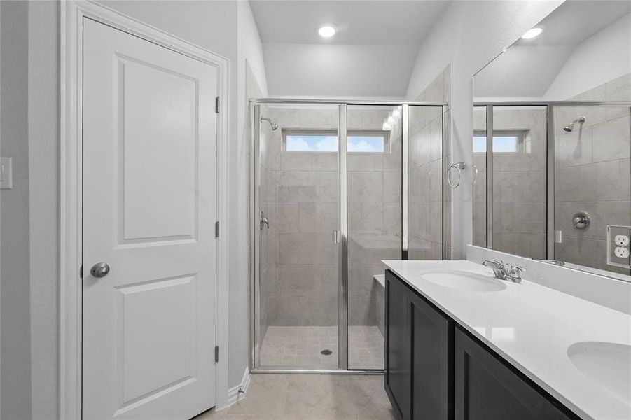 Full bathroom with double vanity, a stall shower, light tile patterned floors, and recessed lighting
