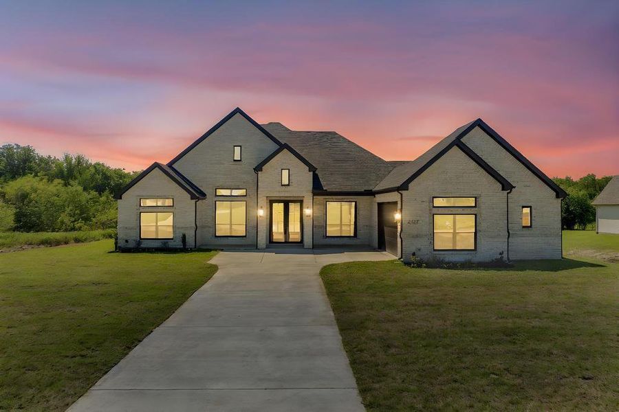 View of front of house featuring brick siding and a front yard