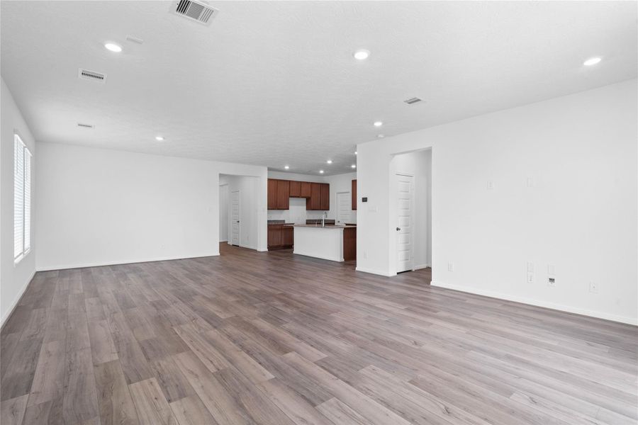 View from the Family Room into the kitchen and hallway towards the secondary bedrooms and entryway. Primary bedroom entrance seen here on the right.