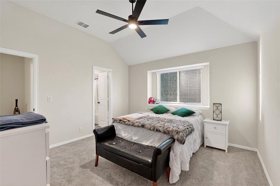 Bedroom with lofted ceiling, light colored carpet, and a ceiling fan Bedroom with lofted ceiling, light colored carpet, and a ceiling fan