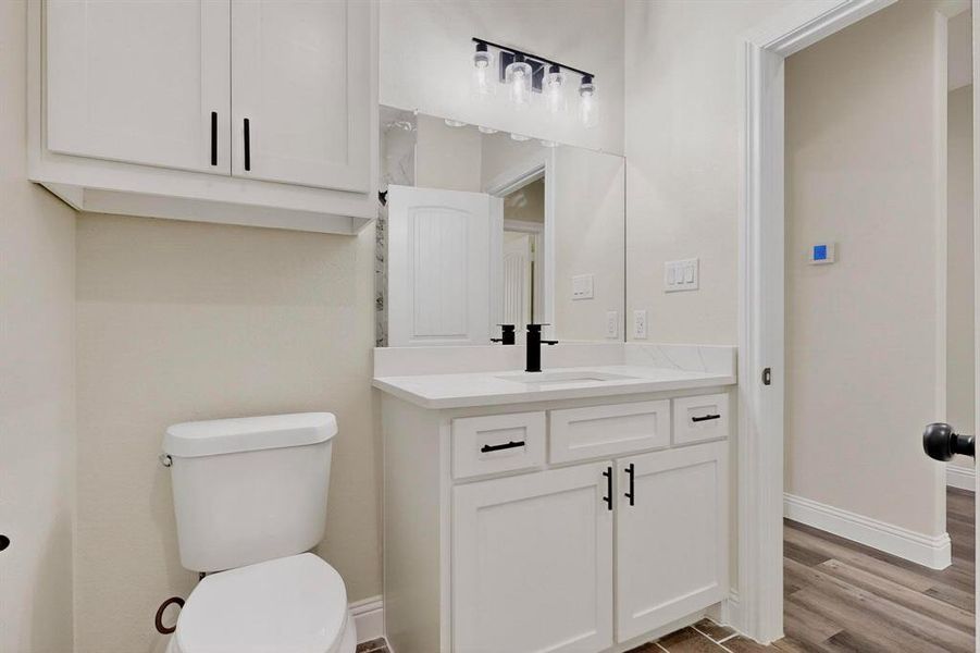 Half bathroom featuring vanity and light wood-style floors Half bathroom featuring vanity and light wood-style floors