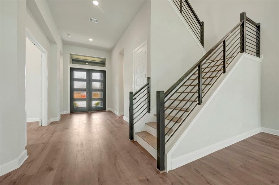 Entryway with light wood-style flooring, french doors, and recessed lighting