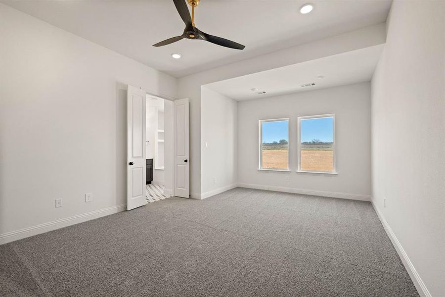 Carpeted spare room with visible vents, baseboards, ceiling fan, and recessed lighting