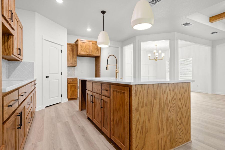 A central kitchen island features ample storage, sleek counters, and an inviting space for gatherings. A central kitchen island features ample storage, sleek counters, and an inviting space for gatherings.