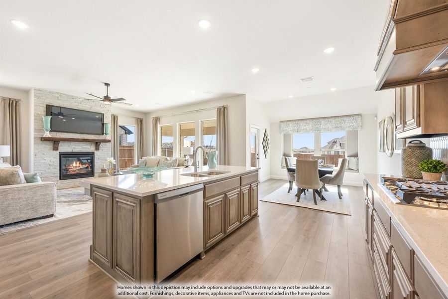 Open-concept kitchen with large island, wood cabinets, and hardwood floors flowing into living and dining areas with fireplace Open-concept kitchen with large island, wood cabinets, and hardwood floors flowing into living and dining areas with fireplace