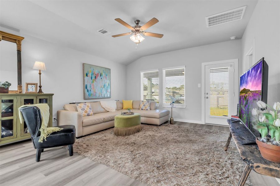 Great room is light filled with windows across the back and just steps from covered back patio.