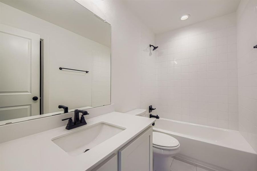 Bathroom featuring vanity, shower combination, tile patterned flooring, and recessed lighting Bathroom featuring vanity, shower combination, tile patterned flooring, and recessed lighting