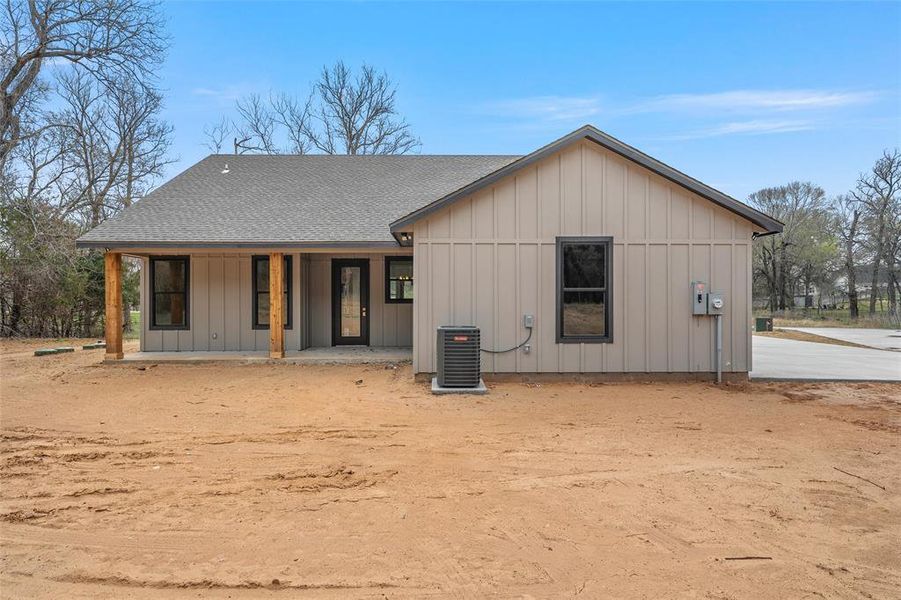View of front of home featuring board and batten siding, roof with shingles, and a porch