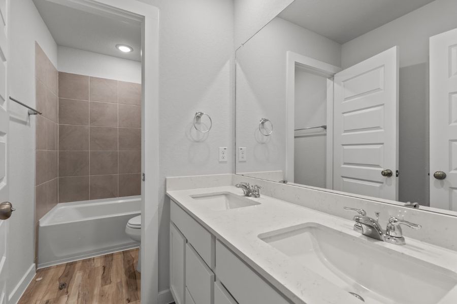 A bathroom with a tub sink and toilet.