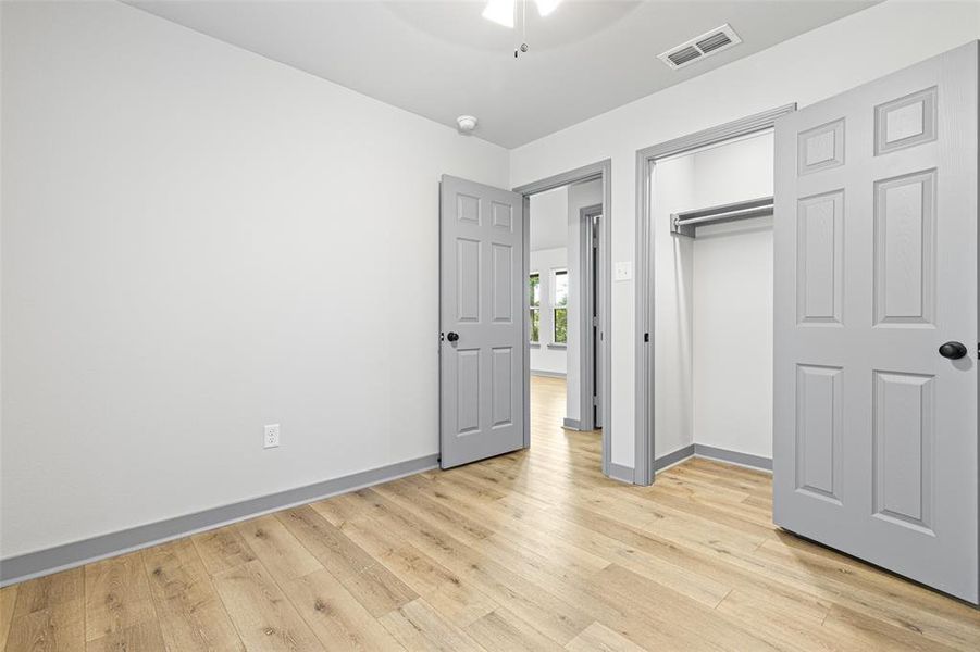 Unfurnished bedroom with light wood-style flooring, a closet, and a ceiling fan Unfurnished bedroom with light wood-style flooring, a closet, and a ceiling fan