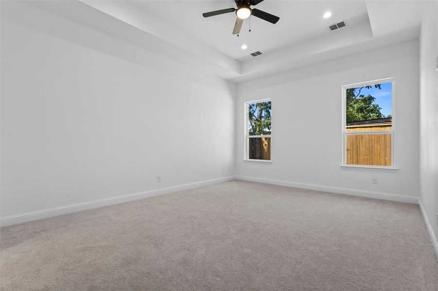 Carpeted empty room with a tray ceiling, a ceiling fan, and recessed lighting Carpeted empty room with a tray ceiling, a ceiling fan, and recessed lighting