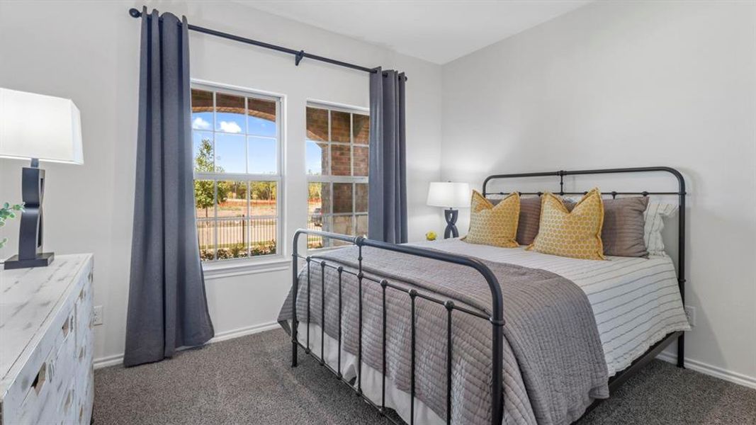 Bedroom with dark carpet and baseboards
