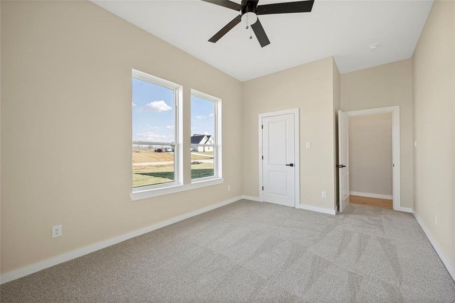 Unfurnished bedroom featuring light carpet, a closet, and ceiling fan