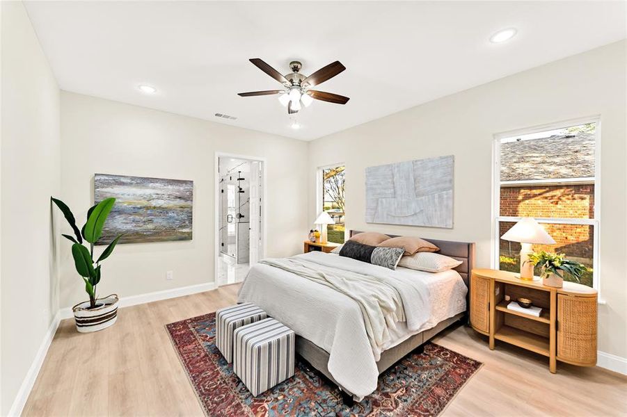 Bedroom with ceiling fan, light hardwood / wood-style floors, and ensuite bath