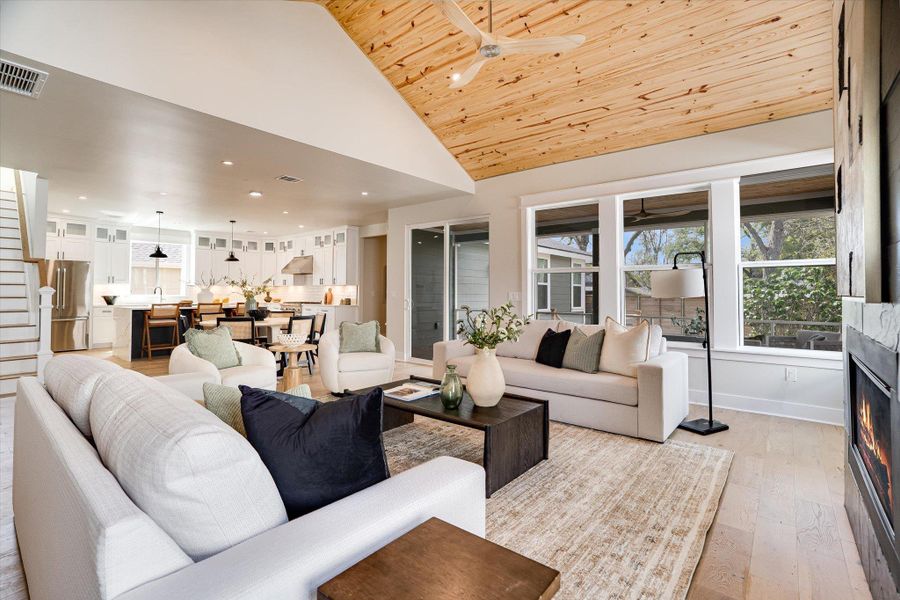 The property features a spacious living area with a vaulted wood-paneled ceiling, large windows, and a fireplace The property features a spacious living area with a vaulted wood-paneled ceiling, large windows, and a fireplace