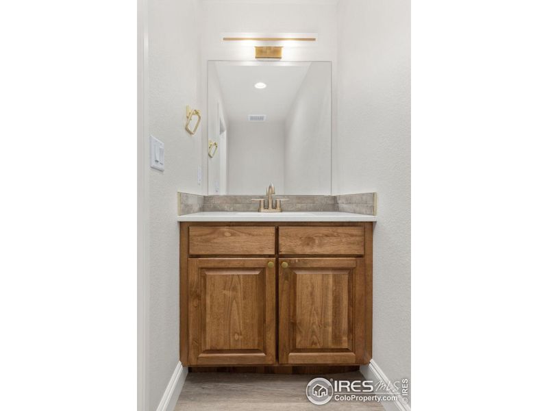 The main floor powder bath is in the center of the home near the laundry/mudroom and right off the great room