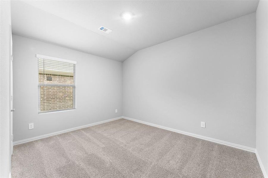 Unfurnished room featuring carpet and lofted ceiling Unfurnished room featuring carpet and lofted ceiling