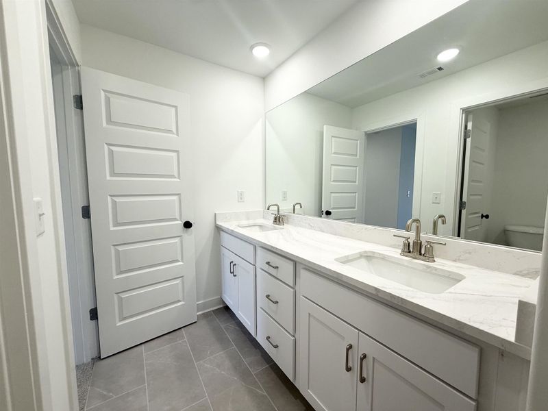 Bathroom with double vanity and recessed lighting