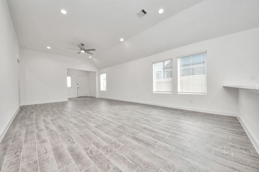 Gather the family and guests together in your lovely living room! Featuring soaring high ceilings, recessed lighting, ceiling fan, custom paint, gorgeous floors, and large windows that provide plenty of natural lighting throughout the day.