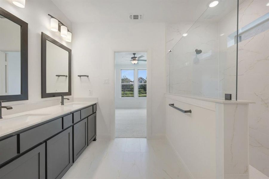 Bathroom featuring a dual vanity with dark cabinetry, rectangular sinks, and matte black fixtures